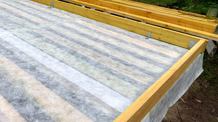 Wooden beams frame a freshly laid vapor barrier, evoking the magic of construction's silent groundwork, akin to Archtobers architectural celebration