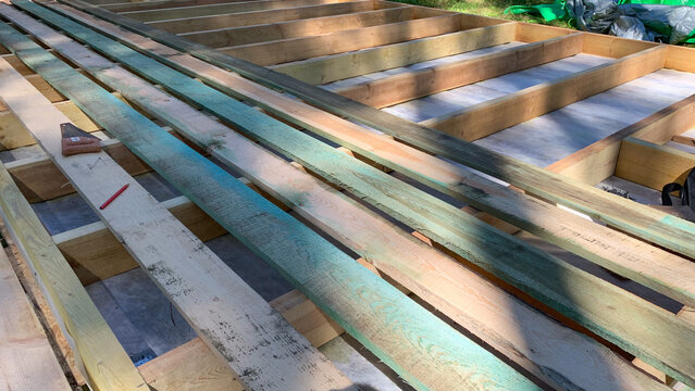 Sunlit planks cast geometric shadows, whispering tales of renewal and crafting dreams, resonant with Arbor Day's silent promise