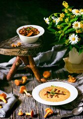 Rustic mushroom soup with chanterelles, autumn harvest feast, Nordic comfort food, cozy hygge dining, amidst daisies and woodsy warmth