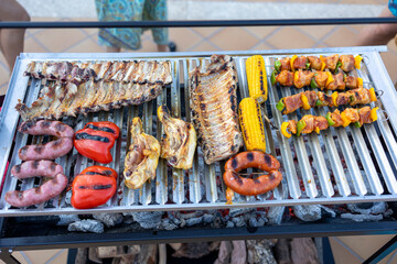Barbecue grilling spare ribs, chicken, sausages, corn and pork skewers