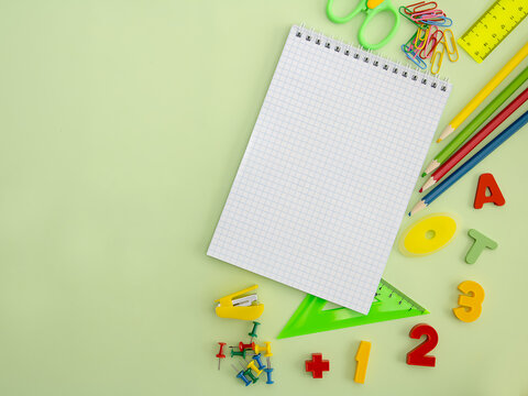 Flat stand with school stationery on a green background, top view