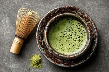 Chawan with fresh matcha tea and chasen on grey background, top view. High quality