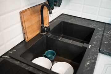 Pile of unwashed, dirty dishes in the sink.