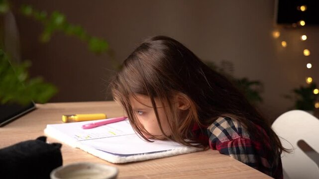 Young girl struggles with homework at a table in a cozy room during the afternoon