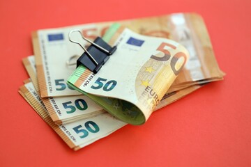 Big amount of european euro currency money notes on red color table close up
