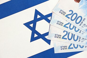 Israel New Shekels banknotes on national flag. The current Israel money bills lies on flag