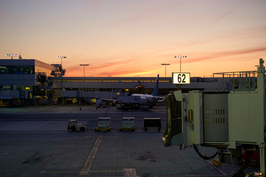 Airport gate view with a plane at sunset. Los Angeles, USA