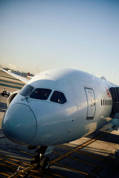 A large commercial airplane parked at an airport gate under a clear blue sky. Los Angeles, USA