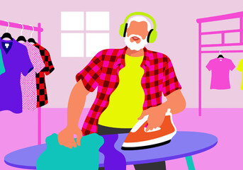 A senior man listening to music on headphones while ironing clothes at home. Self-care, independence, and daily routine.