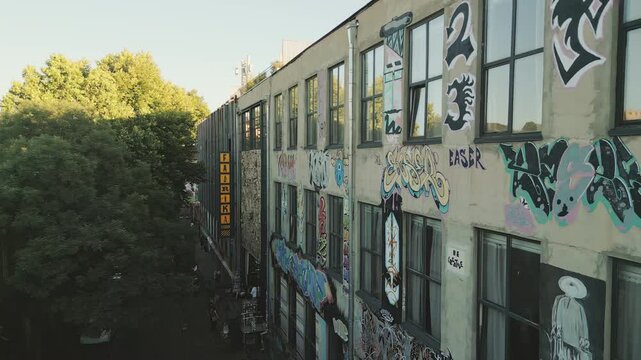 Tbilisi, Georgia - 1st july, 2025: Close up view of Fabrika hostel facade in Tbilisi with vibrant yellow sign and preserved Soviet‑era bas‑relief artwork depicting industrial and cultural motifs