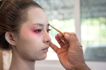 Close up make up artist doing geisha make up for maiko woman