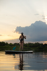 Paddleboarding at Sunset on a Tranquil Lake