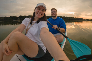 Couple Paddleboarding at Sunset