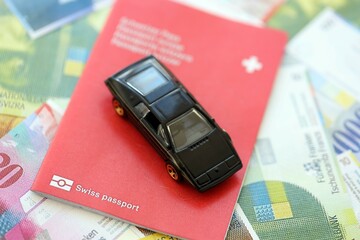 Swiss franc banknotes and toy car with passport. The current francs money bills and car with pass
