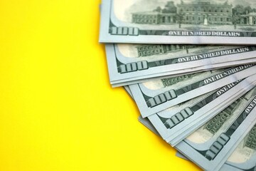 Big amount of United States hundred dollar bills on yellow background