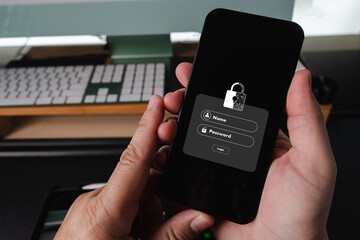 Cybersecurity Data privacy person holding smartphone with login screen for security app, showing padlock icon and login fields, office setting