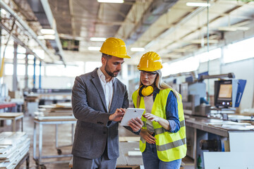Engineers Discussing Project Details in a Modern Factory Setting