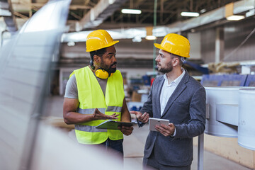 Engineers Discussing On-Site Work Plans in an Industrial Environment While Collaborating