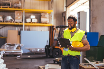 Warehouse Worker Reviewing Documents with Safety Equipment in an Industrial Setting