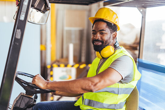 Smiling Worker Operating a Forklift in a Warehouse Setting Wearing Safety Gear - Powered by Adobe