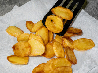 The best potato snack, crispy fried slices laid out on a paper towel