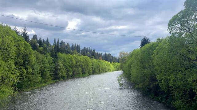 mountain river, a strong rapid current in the middle of a mountainous flatter area, rainy weather, underwater stones, fresh water, a stream of water, a shallow reservoir