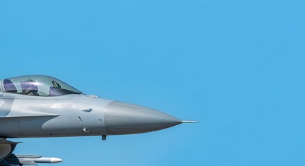 A modern military jet aircraft against a clear blue sky, angled view.