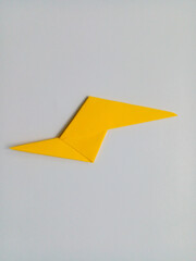 Yellow lightning origami isolated on white background.