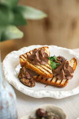 Chicken liver pate on grilled toast with fig jam in restaurant setting
