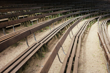 Reihen von verwitterten Holzbänken in einer Freiluft-Amphitheater