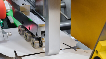 Elements of corton boxes are collected in stack. Conveyor line for the production of boxes. Machine...