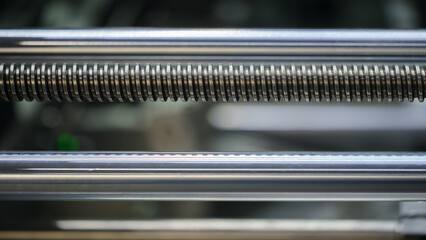 Screw drive as part of industrial machine or conveyor, industrial concept background.