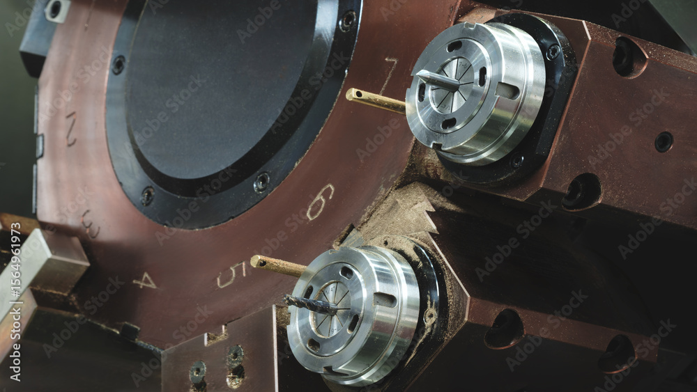 Poster CNC Machine with a brown casing and a silver part.  machine is used for drilling. machine has a small hole in the middle