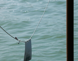 Calm waters and metal cable with sign over a lake