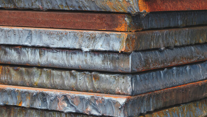 Stack of metal sheets with rust. plates are stacked on top of each other and have traces of laser plasma cutting. Industrial concept background.