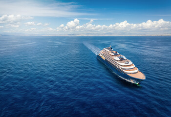 Aerial front view of a modern luxury cruise ship or yacht sailing with speed over calm ocean with...