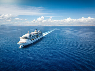 Aerial front view of a generic cruise ship sailing with speed over calm ocean with copy space