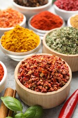 Different aromatic spices in bowls on table, closeup