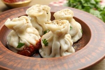 Tasty khinkali with spices on wooden table, closeup