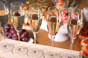 Buffet menu. Glasses of sparkling wine and tasty appetizers on table, closeup