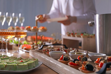 Buffet menu. Woman taking tasty tartlet from table, selective focus
