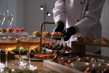 Chef arranging appetizers on buffet table, closeup