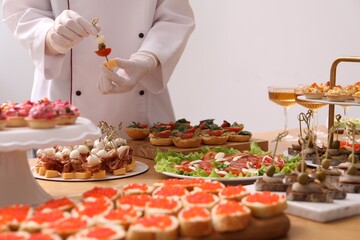 Chef arranging appetizers on buffet table, closeup