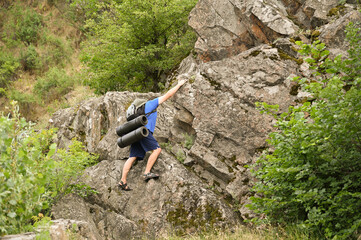man in sports suit with backpack doing active sports on mountain