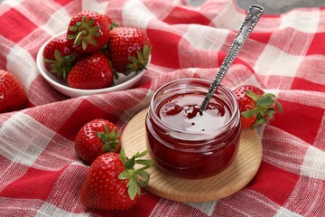 Tasty homemade strawberry jam and berries on table, closeup
