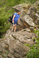 man in sports suit with backpack doing active sports on mountain