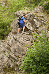 Fototapeta premium man in sports suit with backpack doing active sports on mountain