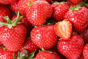 Fresh whole and cut strawberries as background, top view