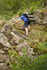 man in sports suit with backpack doing active sports on mountain