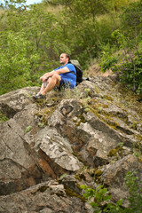 man in sports suit with backpack doing active sports on mountain